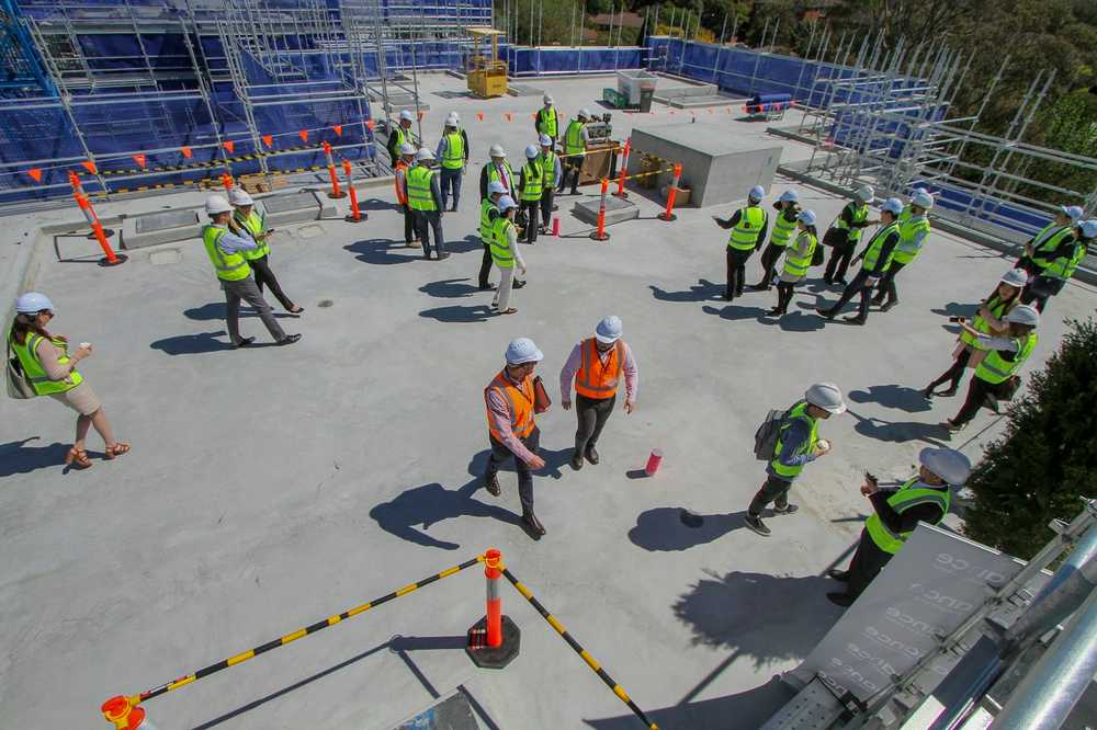 A construction crew in hi-vis gathered for a site induction