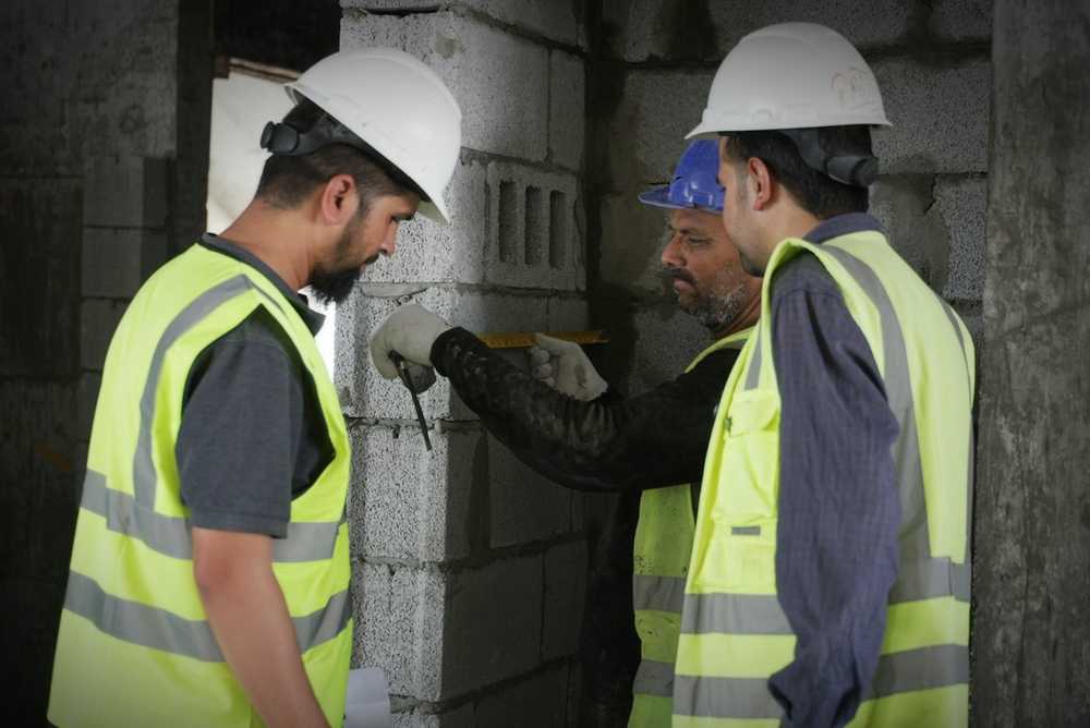 Workers in hi-vis and hard hats checking a job on site